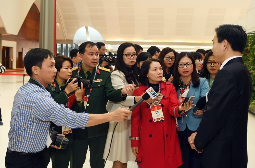 Phóng viên Báo Quân đội nhân dân và các đồng nghiệp thực hiện một buổi phỏng vấn đại biểu.